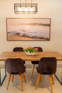 a dining room table with two chairs and a bowl of flowers on it at Casa 4 Suítes - Ilha do Boi in Vitória