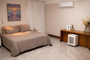 a bedroom with a bed and a tv in it at Casa 4 Suítes - Ilha do Boi in Vitória