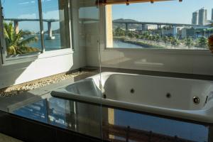 a bath tub in a bathroom with a window at Casa 4 Suítes - Ilha do Boi in Vitória