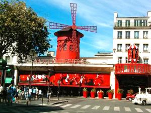 un edificio rojo con un molino de viento encima en Le Bienvenue, en Bussy-Saint-Georges