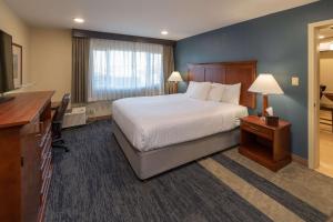 Habitación de hotel con cama, escritorio y TV. en Best Western Plus Clocktower Inn, en Billings