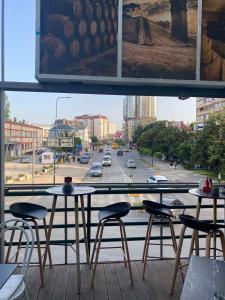 a balcony with two tables and chairs and a street at Hotel City Rooms Prishtina in Pristina