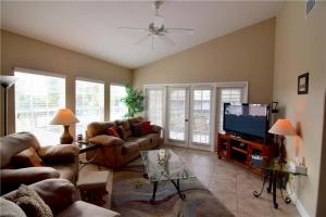 a living room with couches and a flat screen tv at Water Views & Community Pool - Condo Casa Marbella - Roelens Vacations in Cape Coral