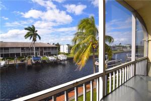 a view from a balcony of a marina with palm trees at Water Views & Community Pool - Condo Casa Marbella - Roelens Vacations in Cape Coral
