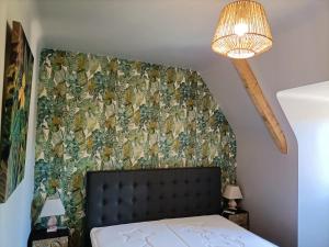 una camera da letto con un letto e una parete ricoperta di carta da parati di La Villa Perigourdine a Sarlat-la-Canéda