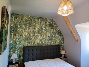 a bedroom with a bed and a wall covered in wallpaper at La Villa Perigourdine in Sarlat-la-Canéda