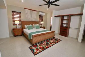 ein Schlafzimmer mit einem Bett und einem Deckenventilator in der Unterkunft Casa Belcher (Ray's) in Cozumel