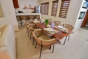ein Esszimmer mit einem Holztisch und Stühlen in der Unterkunft Casa Belcher (Ray's) in Cozumel