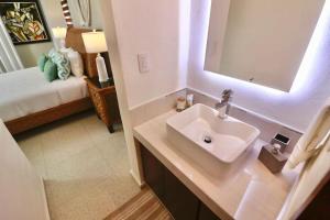 ein Badezimmer mit Waschbecken und Spiegel und einem Bett in der Unterkunft Casa Belcher (Ray's) in Cozumel + 9 Fotos