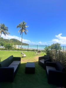 d'une terrasse avec des canapés et une vue sur la plage. dans l'établissement STUDIO VUE MER VILLAGE VIVA BAS DU FORT, Gosier, au Gosier