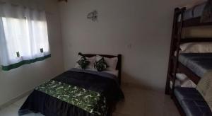 Cette petite chambre comprend un lit et des lits superposés. dans l'établissement Eco Chalés Pedra Bela, à Pedra Bela