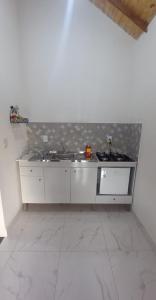 - une cuisine blanche avec évier et comptoir dans l'établissement Eco Chalés Pedra Bela, à Pedra Bela