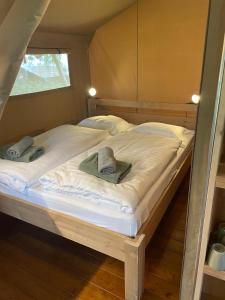 a bedroom with two beds with hats on them at Safari Tent M in Berdorf