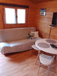 sala de estar con sofá y mesa en Domki letniskowe Przyczepy kempingowe Zacisze Mielno, en Mielno