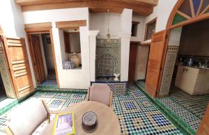 um quarto com uma mesa e piso em azulejo em Dar Houdou em Fez