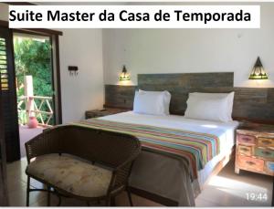 a bedroom with a bed and a chair and a window at Casa Verde Apart - Aptos e Casa Residencial in Praia do Forte