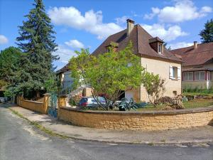 una casa con un muro di mantenimento di fronte a una strada di La Villa Perigourdine a Sarlat-la-Canéda