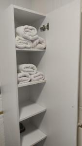 a bathroom closet with white towels on the shelves at Müstakil Villa Dairesi in Kavala