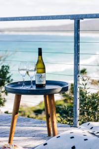 a bottle of wine and two wine glasses on a table at Holland House Bay of Fires in Binalong Bay