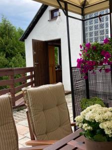 a patio with two chairs and a table with flowers at Cerla Korbielów in Korbielów