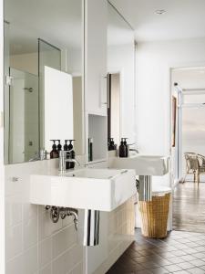 a white bathroom with two sinks and a mirror at Holland House Bay of Fires in Binalong Bay