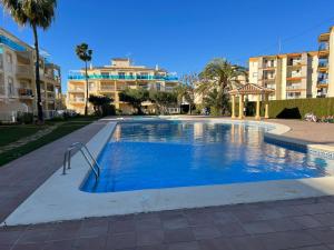 une piscine dans un complexe hôtelier avec des bâtiments en arrière-plan dans l'établissement Denia Holiday Service, à Dénia
