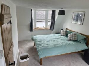 a bedroom with a bed with blue sheets and a window at 2 smw in Peebles