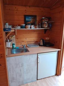 una cocina con fregadero en una cabaña de madera en Domki letniskowe Przyczepy kempingowe Zacisze Mielno, en Mielno