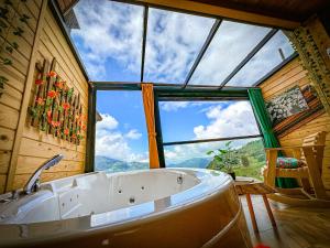 a bath tub in a room with a large window at Organic village bungalow in Ayder Yaylasi