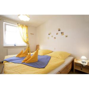 a bedroom with a bed with yellow sheets and a window at Ferienwohnung Lütt-Matt´n -01 in Ahlbeck