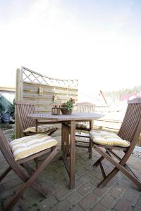 einen Holztisch und zwei Stühle auf einer Terrasse in der Unterkunft Ferienwohnung Lütt-Matt´n -01 in Ahlbeck