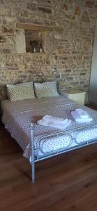łóżko w pokoju z kamienną ścianą w obiekcie Sunset w mieście Rodhiná