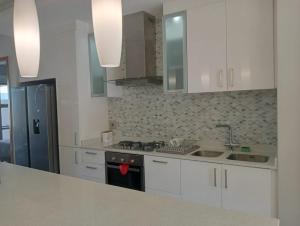 a kitchen with white cabinets and a stove top oven at Stylish modern 2 bed apartment in Shaka's Rock in Ballito