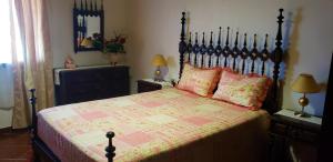 Un dormitorio con una cama grande con cabecero de madera. en Casa da Rústica, en Atalaia de Cima