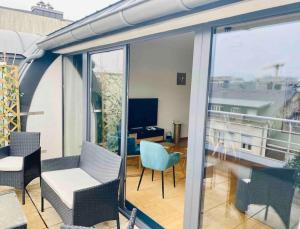 einen Balkon mit Stühlen und einem Tisch auf einem Gebäude in der Unterkunft Penthouse 2 bedrooms in Center with Parking - 51 in Luxemburg (Stadt)