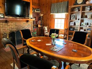 a living room with a wooden table and a fireplace at The Virginia Cliffe Inn in Glen Allen