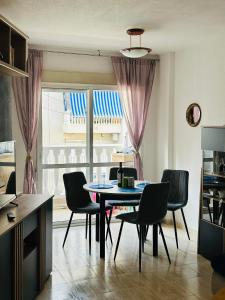 jadalnia ze stołem i krzesłami oraz oknem w obiekcie Apartamento Belsol w mieście Torrevieja