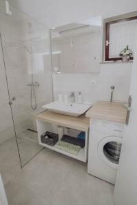 y baño con lavabo y lavadora. en Apartments Peric Županja, en Županja