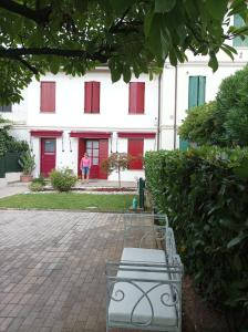 a bench in front of a building with red doors at Casa della Magnolia in Conegliano