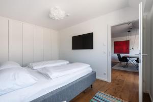 1 dormitorio con 1 cama y TV en la pared en Stylisches Apartment in zentraler Grünruhelage mit Garagenplatz, en Viena