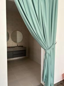 a bathroom with a blue curtain and a sink at The Mountain Farm in Ras al Khaimah