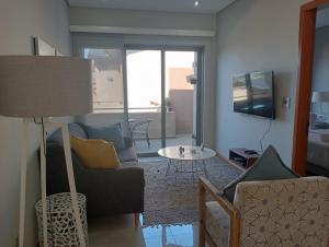 a living room with a couch and a table at Stylish modern 2 bed apartment in Shaka's Rock in Ballito