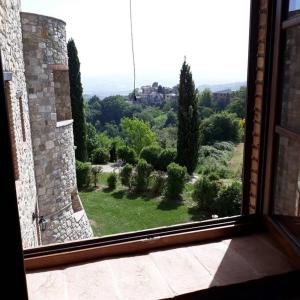 una ventana abierta con vistas al jardín en Country House - La casetta nel borgo, en San Venanzo