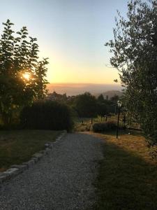 żwirowa ścieżka z zachodem słońca w tle w obiekcie Country House - La casetta nel borgo w mieście San Venanzo