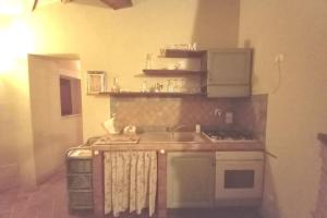 małą kuchnię ze zlewem i kuchenką w obiekcie Country House - La casetta nel borgo w mieście San Venanzo