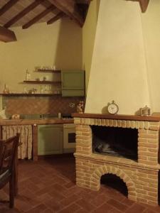 cocina con chimenea de ladrillo en una habitación en Country House - La casetta nel borgo, en San Venanzo