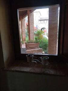 una ventana con dos ollas y un banco en un alféizar de la ventana en Country House - La casetta nel borgo, en San Venanzo