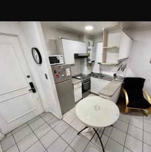 una pequeña cocina con una mesa pequeña y una mesa blanca en Departamento Reñaca, en Viña del Mar