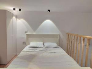 a bedroom with a bed with white sheets and a staircase at U Sea Apartment -1# Location Next to Beach in Tel Aviv