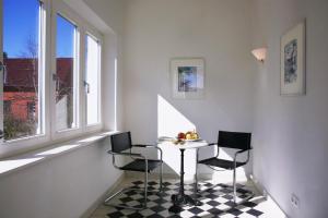 ein Esszimmer mit einem Tisch, 2 Stühlen und einem Fenster in der Unterkunft Villa Daheim - FeWo 01 in Ostseebad Kölpinsee